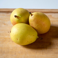 Ripe yellow pears on display on wooden cutting board