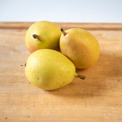 Ripe yellow pears on display on wooden cutting board