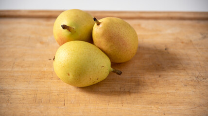 Ripe yellow pears on display on wooden cutting board