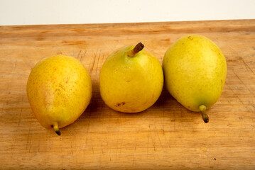 Ripe yellow pears on display on wooden cutting board
