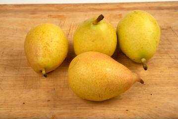Ripe yellow pears on display on wooden cutting board