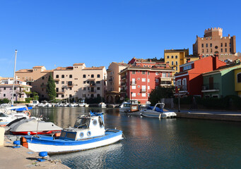 Jetty with yacht. Yachts and motor boats in marina Port Saplaya, Valencia. Yacht and fishing motorboat in yacht club. Colourful houses with apartments at coast Mediterranean Sea. Sailboat near pier.