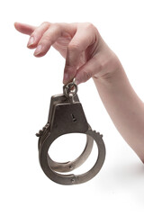 Metal handcuffs with a chain on a light background in a female hand