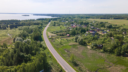 Aerial view of lake and small village. Village near the lake. Aerial view of the village and trees on the shore of lake.