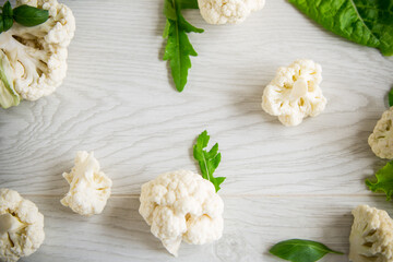 inflorescences of small cauliflower on a light wooden table