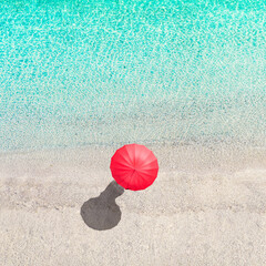 Top view of woman with red summer umbrella walking in tropical blue, turquoise transparent water surface of ocean, sea, lagoon, beach. Aerial, drone view. square