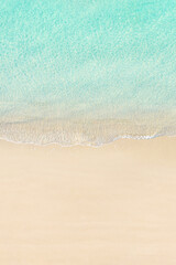 Fototapeta na wymiar Aerial view of yellow umbrella on sandy beach. Summer and travel concept. Blue, turquoise transparent water surface of ocean, sea, lagoon. Aerial, drone view. vertical