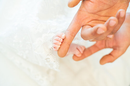 Baby feet before christening in church. Mom and her Child. Beautiful conceptual image of Maternity