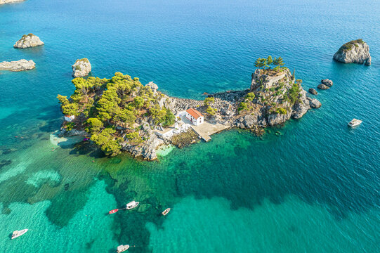 The island of Panagia with church located right in front of the port of Parga among in blue, turquoise sea water. Aerial, top, drone view. Greece