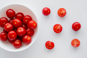 Naklejka na ściany i meble Top view of cherry tomatoes in bowl and on white background.