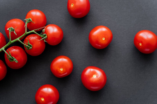 Top view of fresh red cherry tomatoes on black background.