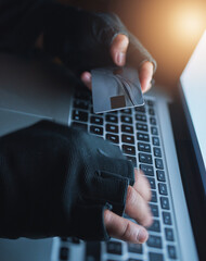 Hackers know exactly how to manipulate financial data. Shot of an unrecognisable hacker using a...