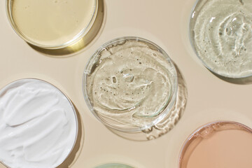 Various cosmetic products in Petri dishes on beige background view from above