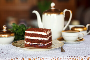 A piece of cake and a cup with a drink on the table.