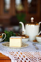 A piece of cake and a cup with a drink on the table.