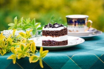A piece of cake and a cup with a drink on the table.