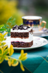 A piece of cake and a cup with a drink on the table.