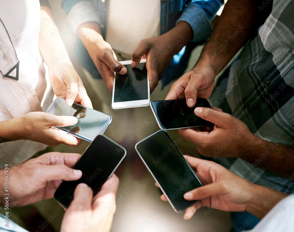 Poster Just press send. Cropped shot of a group of colleagues using their cellphone while standing in a circle.