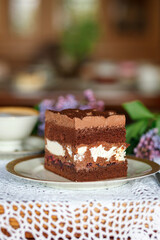 A piece of cake and a cup with a drink on the table.