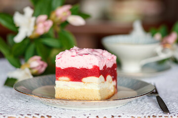 A piece of cake and a cup with a drink on the table.