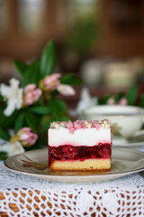 A piece of cake and a cup with a drink on the table.