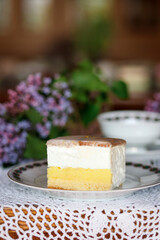 A piece of cake and a cup with a drink on the table.