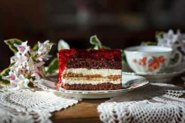 A piece of cake and a cup with a drink on the table.