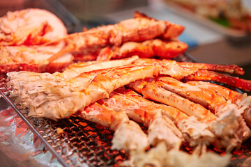 Grilled king crab legs displayed in a traditional market