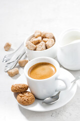 cup of espresso and almond cookies on a white table, vertical, top view