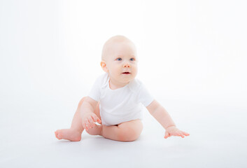 baby boy in a white bodysuit crawling on a white background