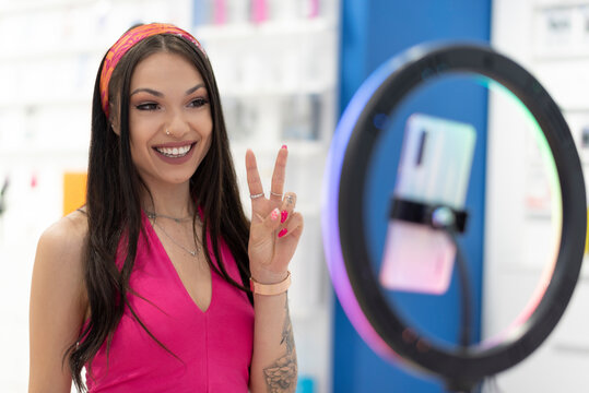 woman transmits content on the internet live through a mobile phone with a beauty dish and a tripod