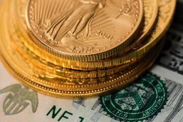 Closeup macro image of a neat stack of golden coins, with a half ounce Golden Eagle coin on top of...