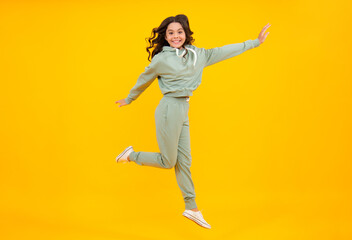 Fototapeta na wymiar Full length of attractive cheerful girl in sport wear isolated over yellow background. Sportwear for teenager child.