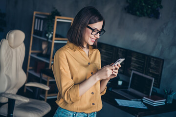 Portrait of attractive cheerful focused girl expert using device gadget app editing post at...