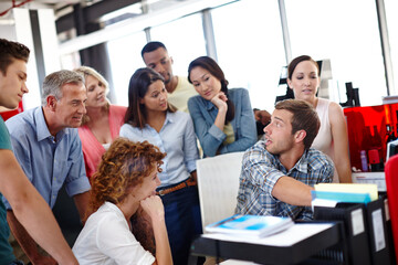 Thats all you need. Shot of a young man explaining something to his colleagues in the office.