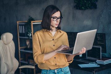 Portrait of attractive focused skilled girl expert typing email editing project task at workplace...