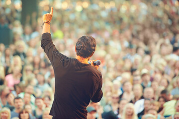 The crowd loves him. A singer performing in front of a massive crowd at a concert.