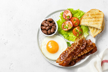 Full English breakfast with baked beans on plate. Top view, copy space.