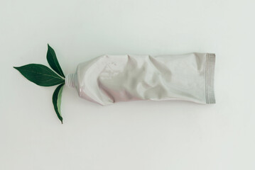 Mockup of crumpled used tube of cream, top view.