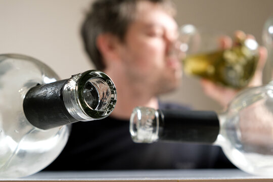 A man with alcohol dependence drinks brine from a jar of aole cucumbers, a man in a hangover.