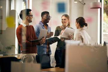Young start up team talking and having fun while working at creative office.