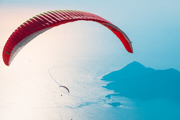 Red open parachute in the blue sky. Oludeniz, Mugla. Summer and vacation background.