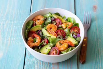Salad with shrimps, avocado, tomatoes, onions and seeds. Healthy eating. Diet.