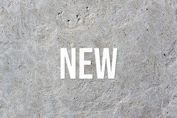 NEW - word on concrete background. Cement floor, wall.