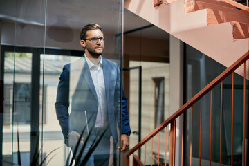 Serious businessman walking up the stairs of an office building.