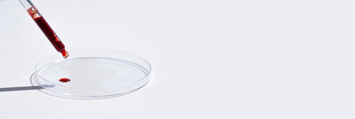 Dropper pipette with serum or red liquid and petri dish on white background. Transparent container...