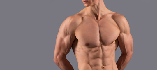 He has a spectacular torso. Shirtless guy with muscular torso. Fit man grey background. Man sexy bare torso, banner with copy space.