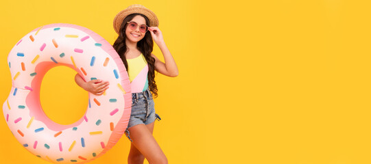 Summer child. suntan. summer vacation. happy girl in straw hat and sunglasses inflatable doughnut ring. Banner of summer child girl in swimsuit, studio poster header with copy space.