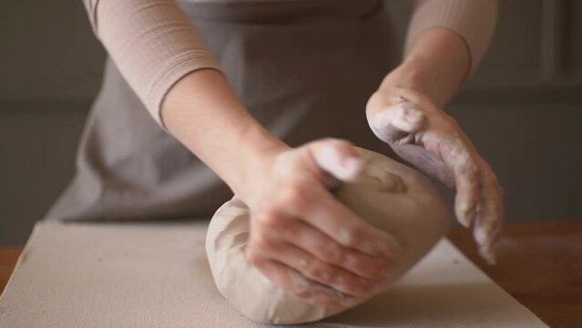 girl prepares clay for work on the desktop