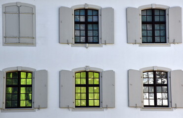 Hausfassade mit bunten Fensterscheiben in Basel